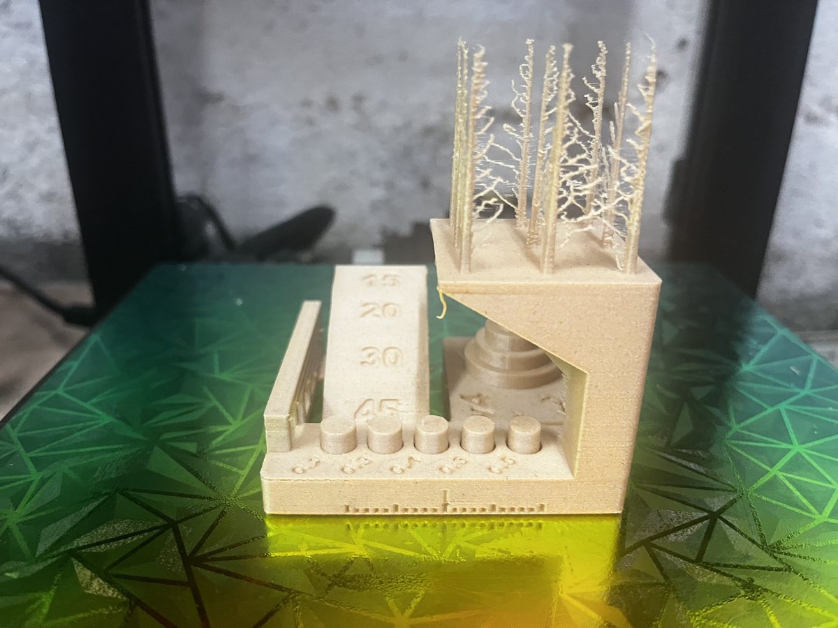Pièce de test en PLA bois AzureFilm couverte de fils, imprimée sur la première machine
