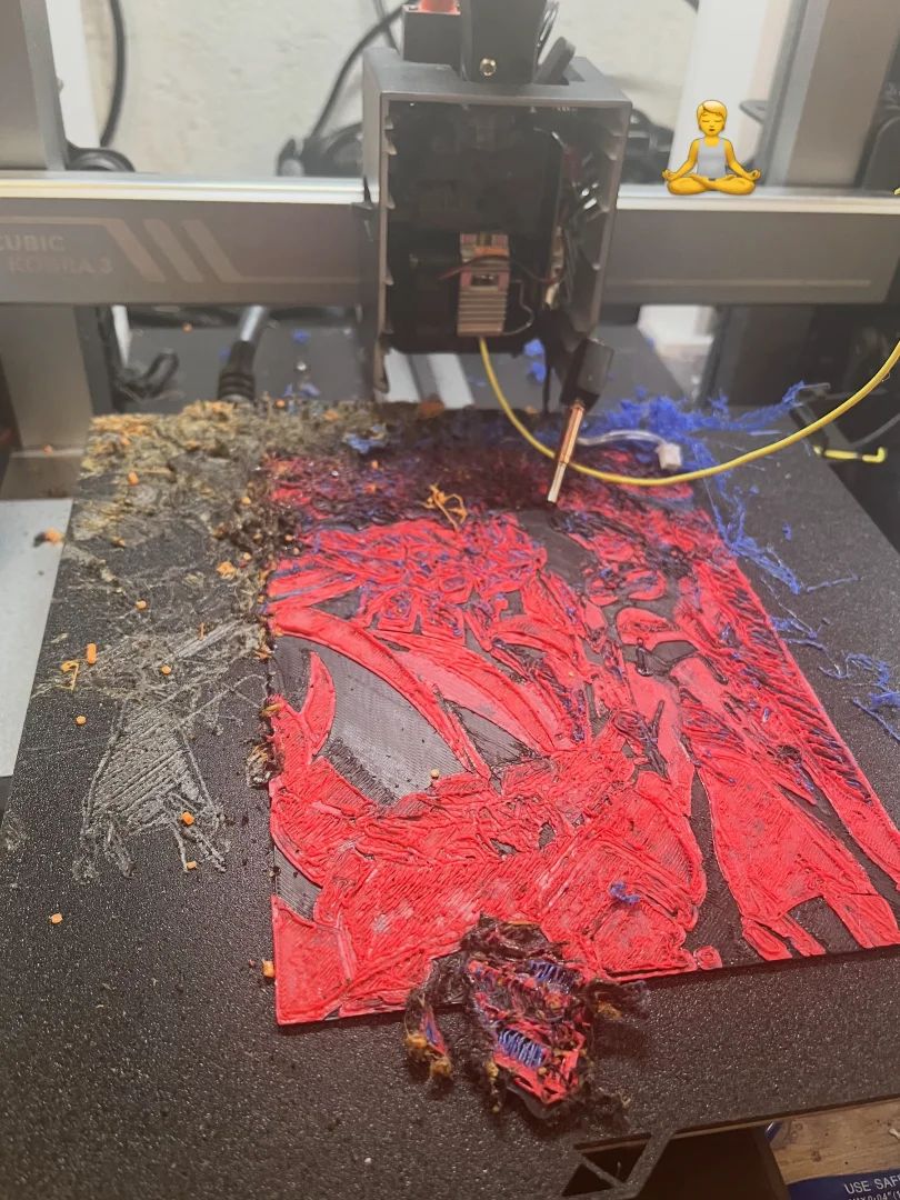 Impression 3D ratée : filament rouge emmêlé en plat de spaghetti sur le plateau d'une imprimante